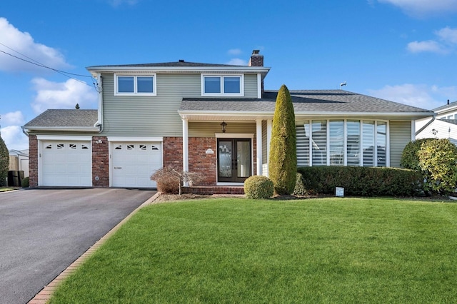 view of property with french doors, a garage, and a front lawn