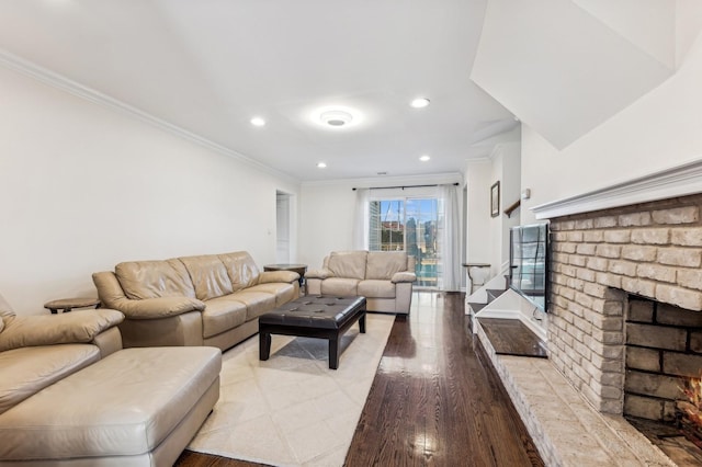 living room with ornamental molding, a fireplace, and light hardwood / wood-style flooring