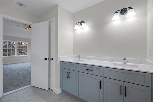 bathroom with hardwood / wood-style floors, ceiling fan, and vanity