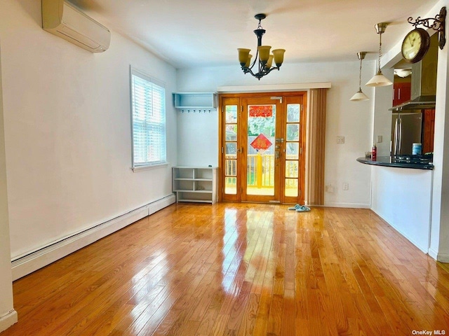 entryway with a chandelier, light hardwood / wood-style floors, an AC wall unit, and a baseboard heating unit