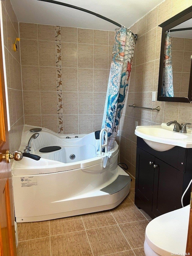 bathroom with decorative backsplash, vanity, tile walls, tile patterned flooring, and toilet