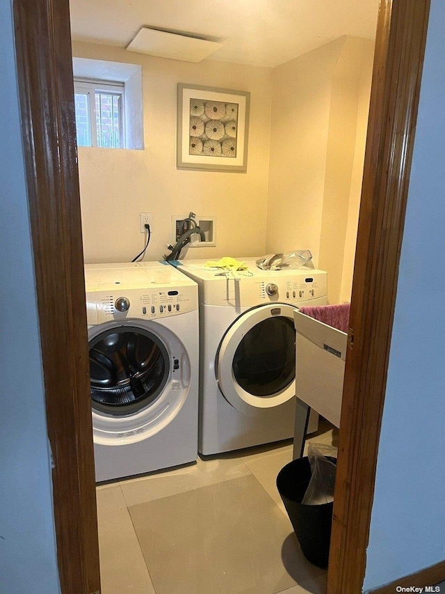 laundry room featuring independent washer and dryer, sink, and light tile patterned floors