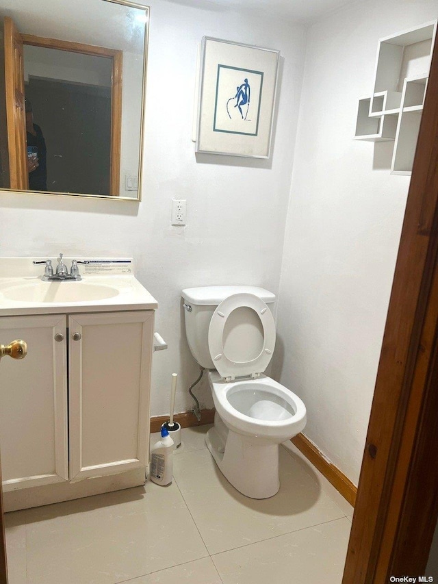 bathroom with tile patterned flooring, vanity, and toilet