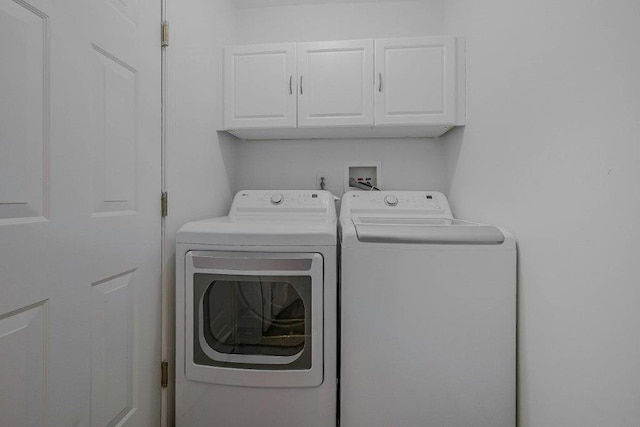 washroom featuring cabinets and washing machine and dryer