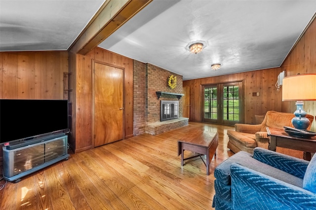 17 Walnut Hill Rd, Poughkeepsie, NY 12603 - living area with wooden walls, light wood finished floors, a brick fireplace, beamed ceiling, and french doors
