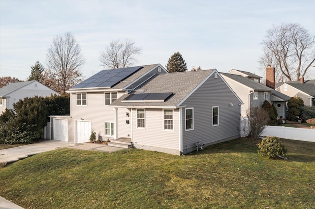 view of front of property featuring a front lawn, a garage, and solar panels