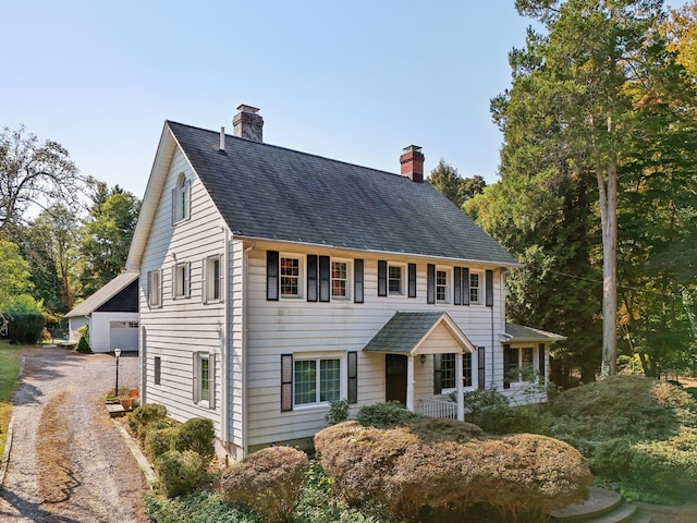 colonial inspired home featuring an outbuilding and a garage