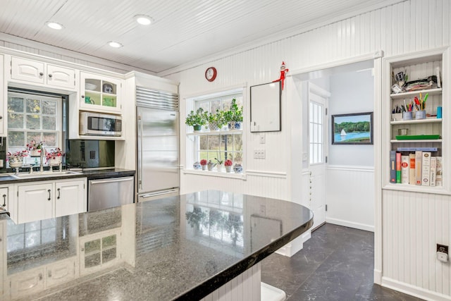 kitchen with dark stone countertops, sink, white cabinets, and stainless steel appliances