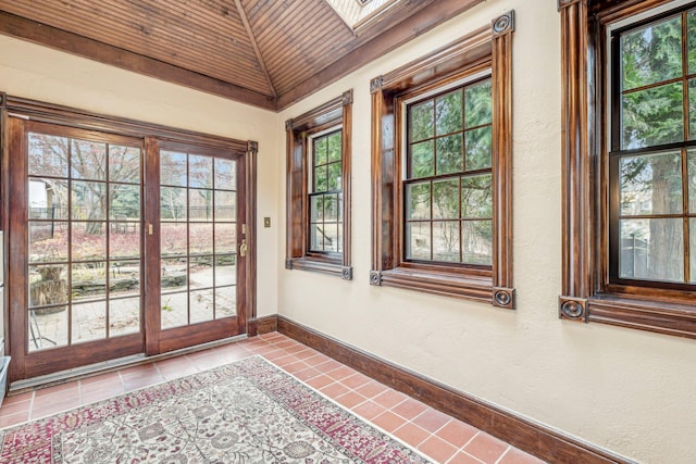 entryway featuring light tile patterned floors, lofted ceiling with skylight, and wood ceiling