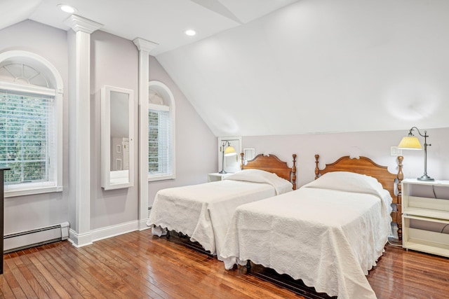 bedroom with baseboard heating, vaulted ceiling, and hardwood / wood-style flooring