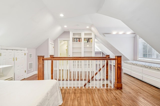 bedroom featuring lofted ceiling, light wood-type flooring, and a closet