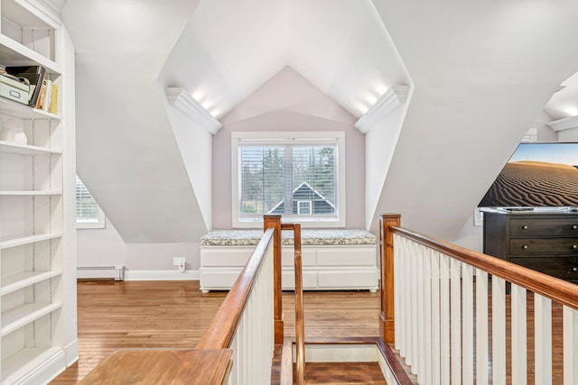 staircase with hardwood / wood-style flooring, a healthy amount of sunlight, and a baseboard heating unit