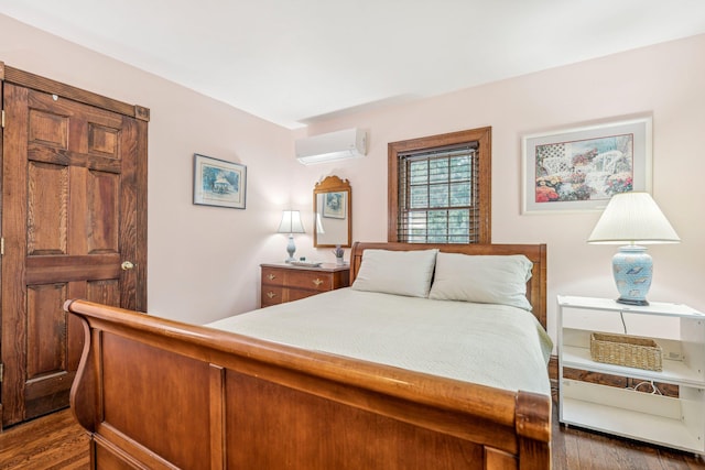 bedroom with dark wood-type flooring and a wall unit AC