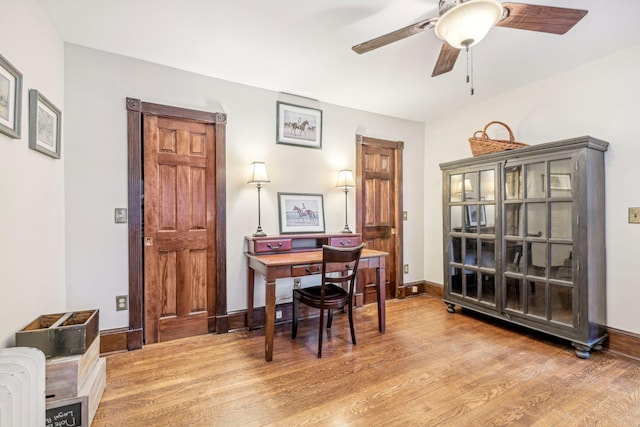 home office with radiator heating unit, light hardwood / wood-style floors, and ceiling fan