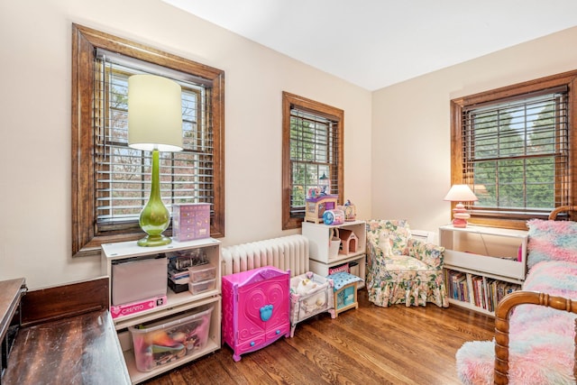 bedroom with hardwood / wood-style floors and radiator heating unit