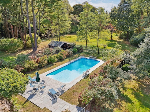 view of swimming pool with a patio, a diving board, and a lawn