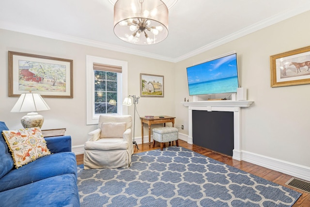 living room with a chandelier, dark wood-type flooring, and ornamental molding