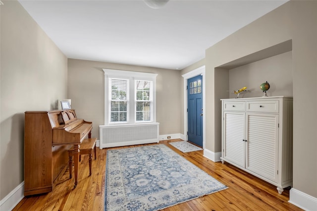 foyer with light wood-type flooring and radiator