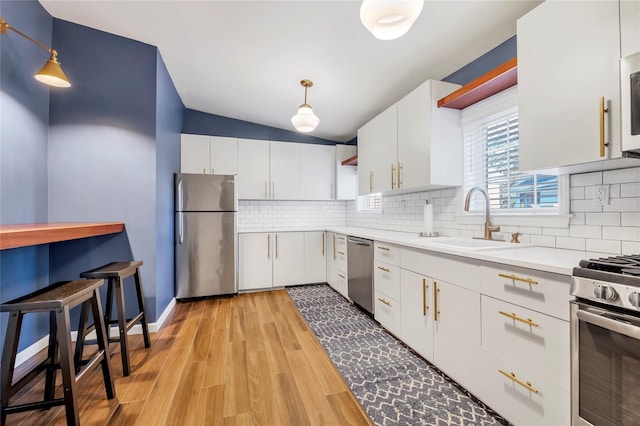 kitchen with white cabinetry, hanging light fixtures, and appliances with stainless steel finishes