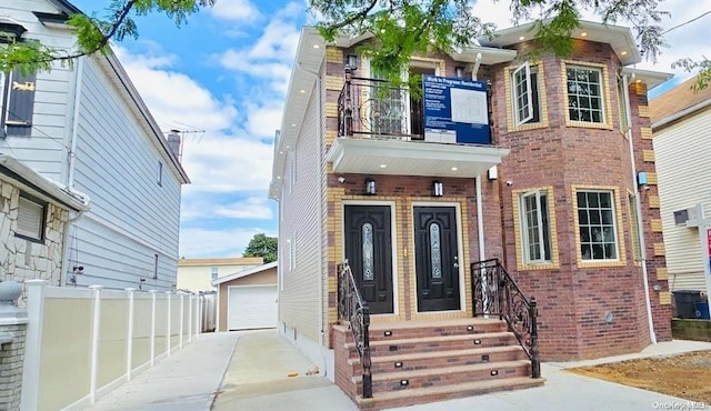 view of front of property with a balcony, a garage, and an outdoor structure