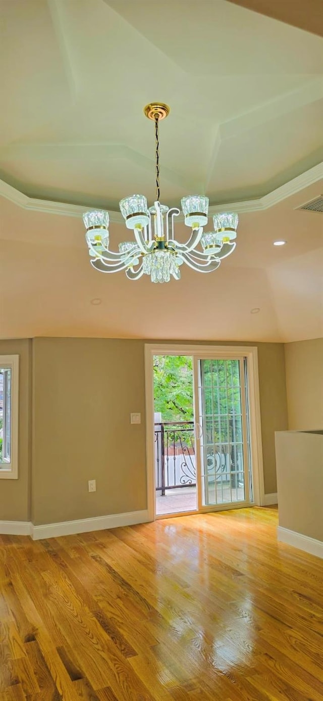 unfurnished dining area with wood-type flooring and a notable chandelier