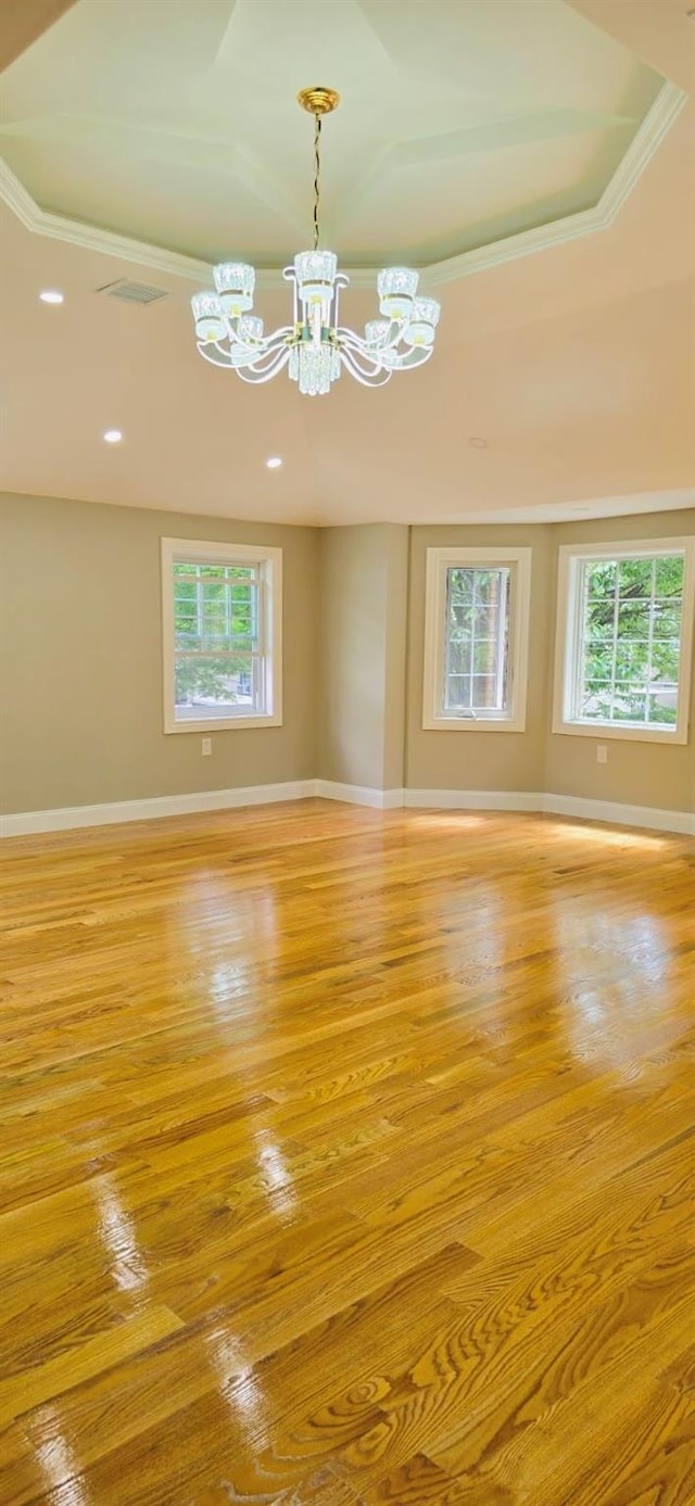 empty room featuring a chandelier, light hardwood / wood-style floors, and ornamental molding