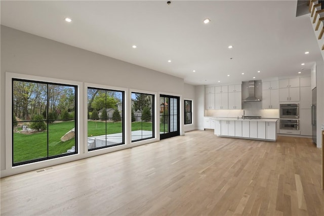 unfurnished living room with light hardwood / wood-style floors and sink