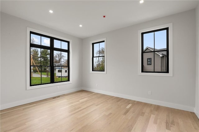 unfurnished room with a wealth of natural light and light hardwood / wood-style floors