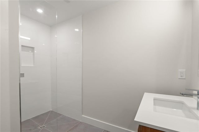 bathroom with a shower, tile patterned flooring, and vanity