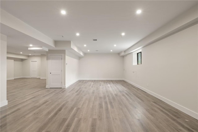 basement with light hardwood / wood-style flooring