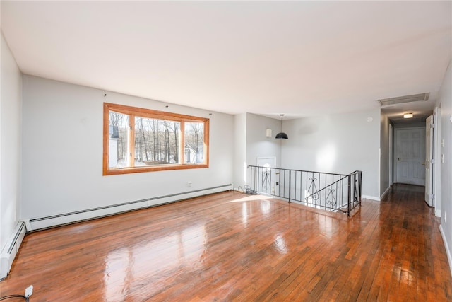 unfurnished room featuring dark hardwood / wood-style floors and baseboard heating