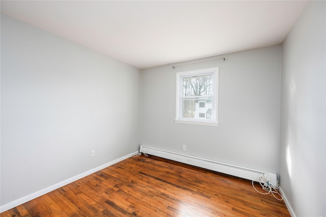 unfurnished room with baseboard heating and hardwood / wood-style flooring