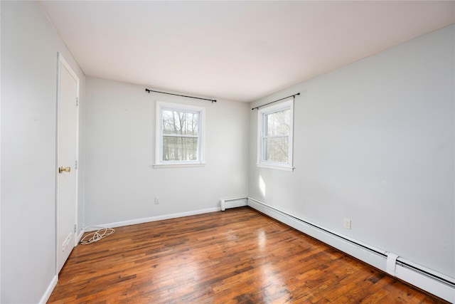 unfurnished room with dark hardwood / wood-style floors and baseboard heating