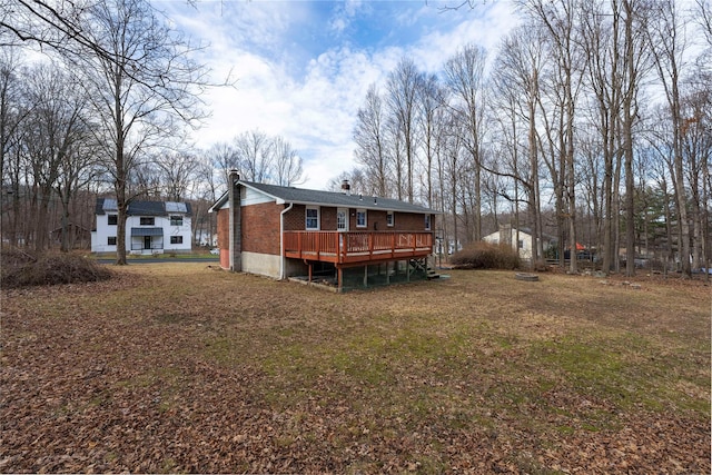 back of house with a lawn and a wooden deck