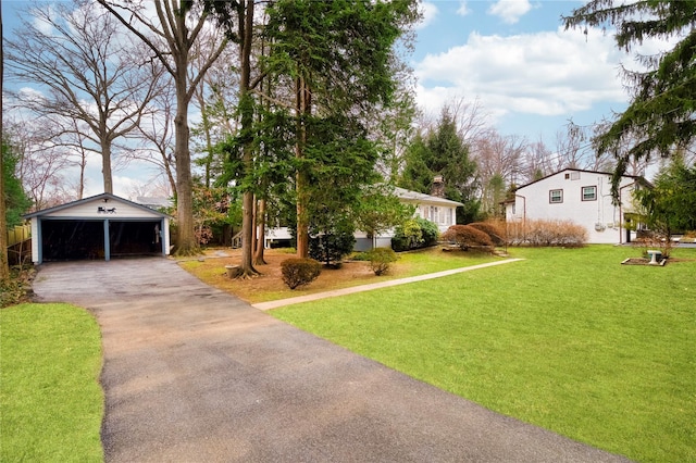 view of yard featuring a garage, a carport, and an outdoor structure