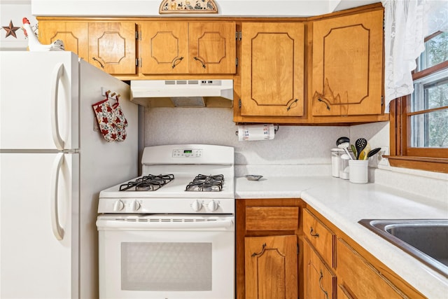 kitchen featuring white appliances and sink