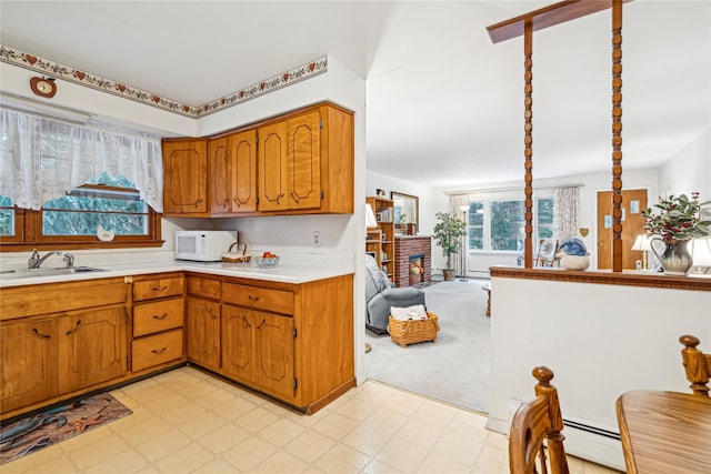 kitchen with a fireplace, sink, and light carpet