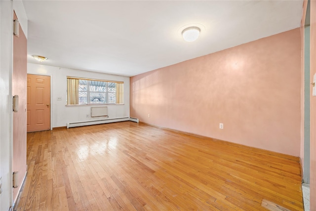 unfurnished room with light hardwood / wood-style flooring and a baseboard heating unit