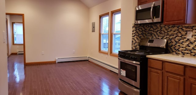 kitchen featuring lofted ceiling, decorative backsplash, dark hardwood / wood-style floors, baseboard heating, and stainless steel appliances