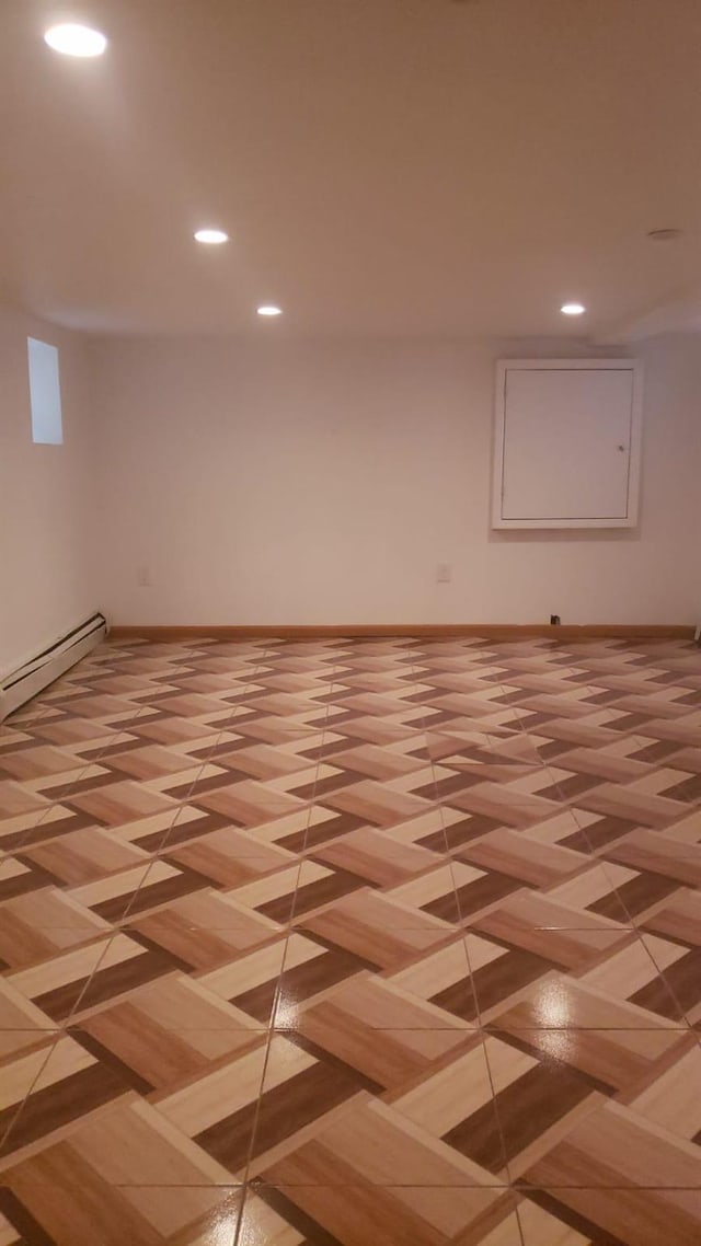 basement with light parquet flooring and a baseboard heating unit