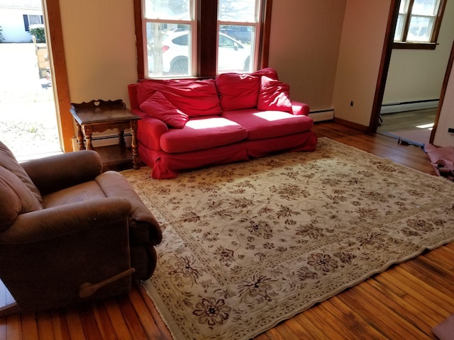 living room featuring baseboard heating, hardwood / wood-style flooring, and a wealth of natural light