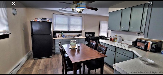 kitchen featuring sink, ceiling fan, hardwood / wood-style floors, black appliances, and a baseboard radiator