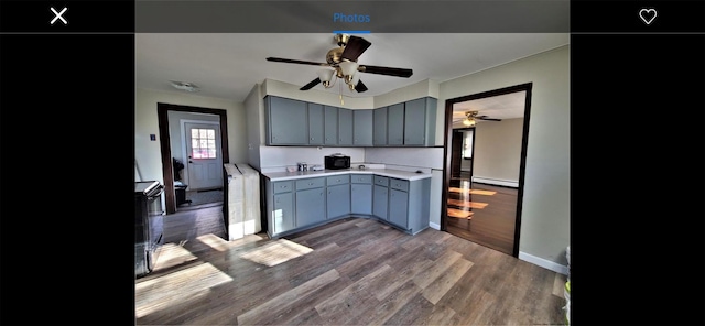 kitchen featuring a baseboard heating unit and dark wood-type flooring