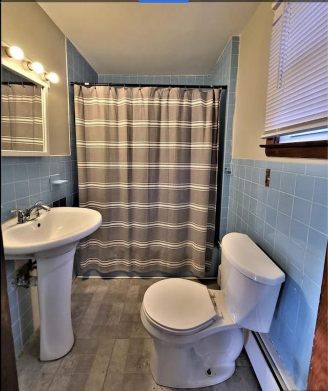 bathroom with walk in shower, toilet, and tile walls