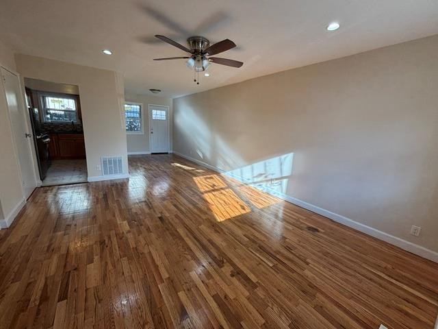 unfurnished living room with ceiling fan and dark hardwood / wood-style flooring