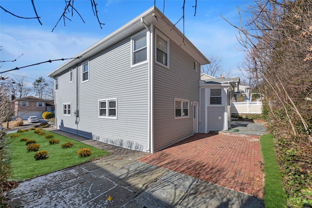 back of property with a patio area and a yard