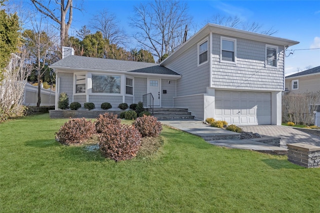 split level home with a front lawn and a garage