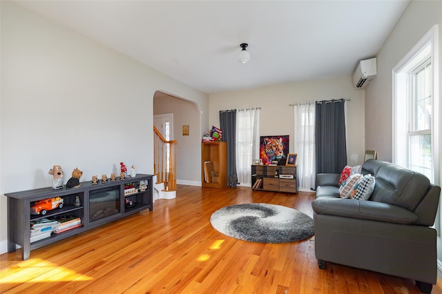 living room featuring hardwood / wood-style floors and a wall mounted air conditioner