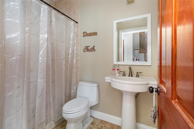 bathroom featuring a shower with shower curtain and toilet