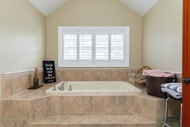 bathroom with tiled tub and vaulted ceiling